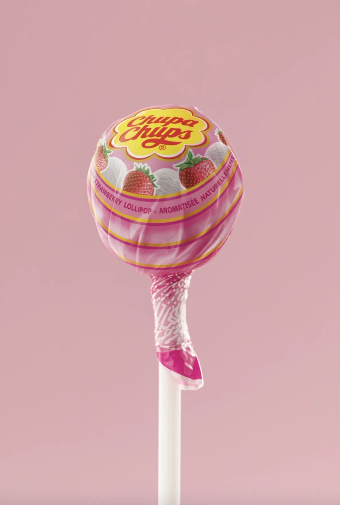 Strawberry lollipop against a pink backdrop