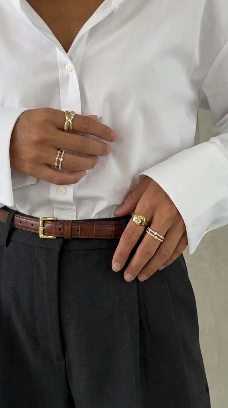 Close-up of gold rings and a leather belt on a white shirt